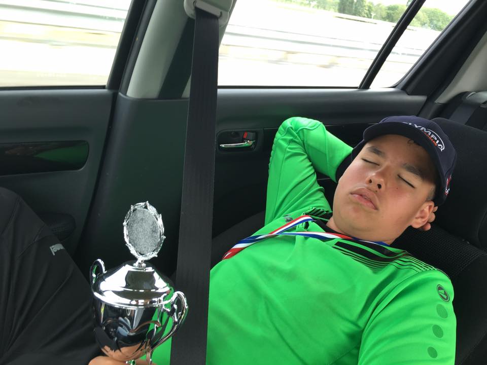 Keeper Bruno slapend met beker op zijn buik terug in de auto naar huis